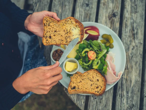 Colpo Ritagliato Giovane Donna Imburrare Pane All Aperto Tavolo Picnic — Foto Stock