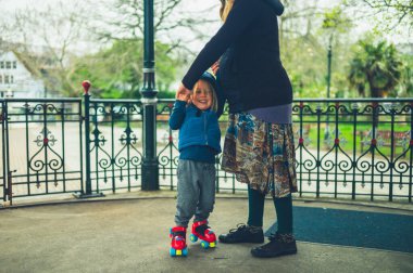 Genç bir anne anaokuluna paten kaymayı öğretiyor.