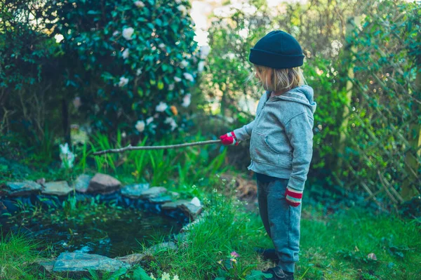 Een Kleine Kleuter Staat Bij Een Vijver Tuin Met Een — Stockfoto