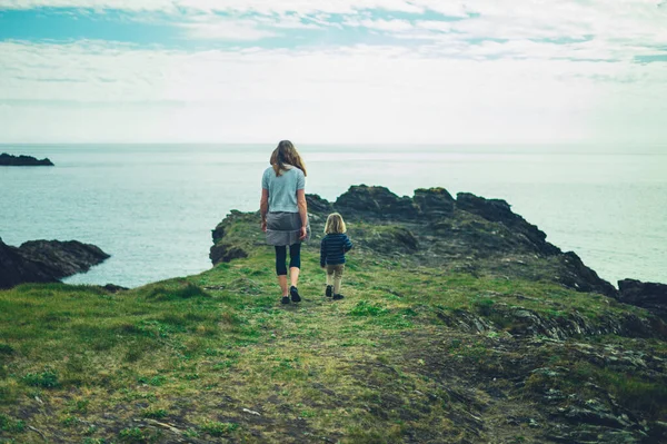 一位母亲和她的学龄前孩子正在海边散步 — 图库照片