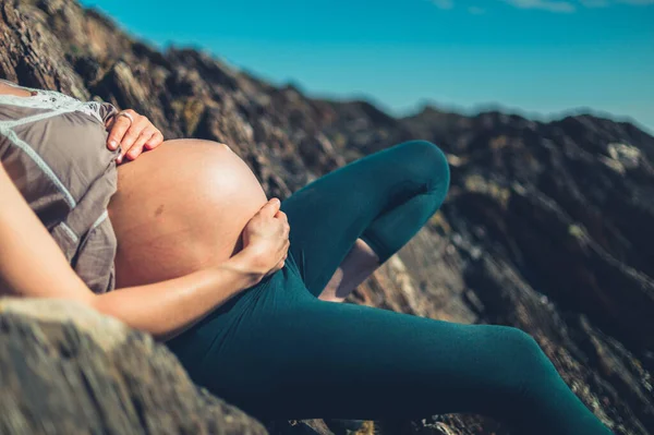 Mladá Těhotná Žena Odpočívá Skalách Moře — Stock fotografie