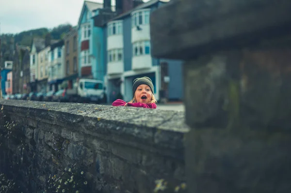 Маленький Дошкольник Смотрит Через Стену Маленьком Городке — стоковое фото