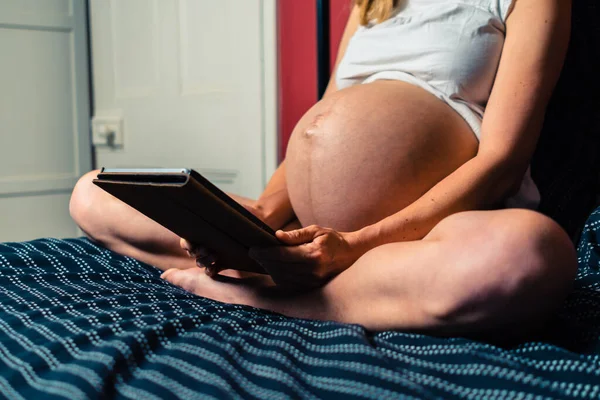 Una Mujer Embarazada Joven Está Usando Una Tableta Cama —  Fotos de Stock