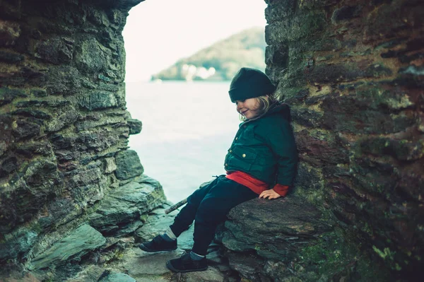 Pequeno Pré Escolar Está Sentado Uma Ruína Pedra Beira Mar — Fotografia de Stock