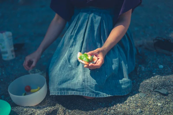 一位年轻妇女正在海滩上野餐 — 图库照片