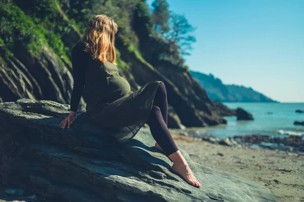 Una Joven Embarazada Está Sentada Una Roca Junto Mar — Foto de Stock