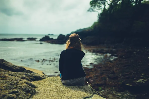 Μια Νεαρή Γυναίκα Κάθεται Στην Παραλία Και Χαλαρώνει Δίπλα Στη — Φωτογραφία Αρχείου