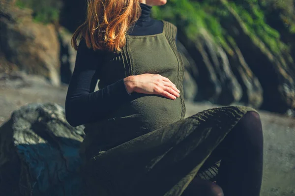 Молодая Беременная Женщина Сидит Скале Моря — стоковое фото