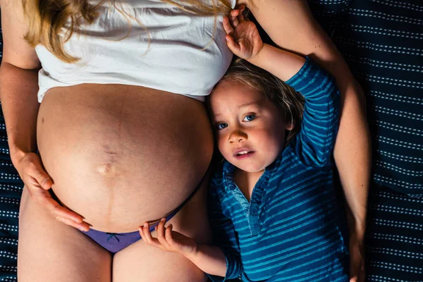 Malý Chlapec Leží Vedle Své Těhotné Matky Posteli — Stock fotografie
