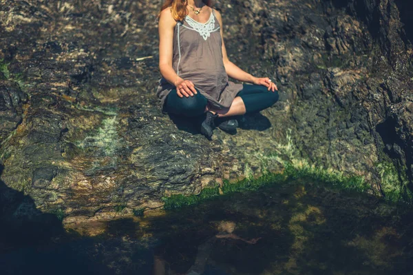 Uma Jovem Mulher Está Sentada Uma Pose Meditação Perto Uma — Fotografia de Stock