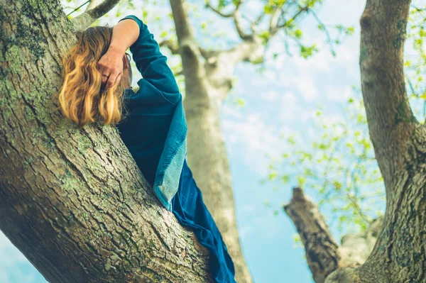 灰の木の枝に若い女性が横たわっている — ストック写真