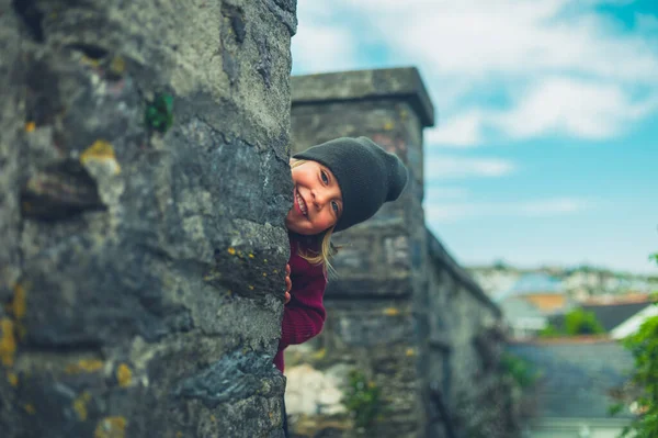 Petite Maternelle Regardant Derrière Mur Dans Une Petite Ville — Photo