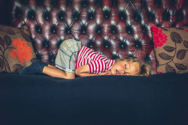 小さな未就学児が家でソファの上で寝ている — ストック写真