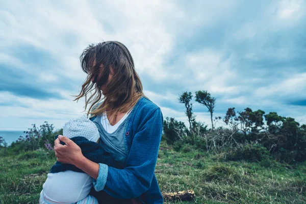 Uma Jovem Mãe Está Amamentando Seu Bebê Beira Mar Prado — Fotografia de Stock