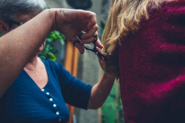 Een Oudere Vrouw Knipt Een Jonge Vrouw Haar Buiten — Stockfoto