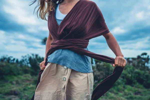 Young Woman Meadow Tying Baby Carrier Sling — Stock Photo, Image