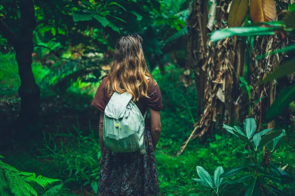 一位年轻女子正在探索一个热带花园 — 图库照片