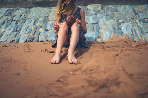 Uma Jovem Mãe Está Sentada Praia Com Seu Bebê — Fotografia de Stock