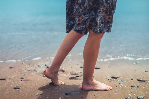 夏に海岸を歩く若い女性の足と足 — ストック写真