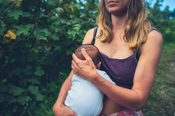 Μια Νεαρή Γυναίκα Θηλάζει Μωρό Της Στη Φύση — Φωτογραφία Αρχείου