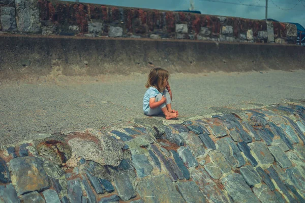 Küçük Bir Anaokulu Öğrencisi Yazın Deniz Kenarındaki Kayalarda Oturuyor — Stok fotoğraf