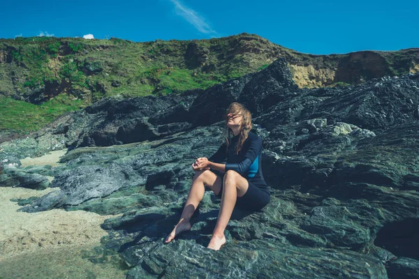 Молодая Женщина Сидит Скалах Моря Летом Гидрокостюме — стоковое фото