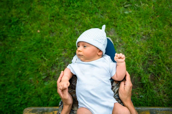 Küçük bir bebek dışarıda annesinin kucağında dinleniyor.
