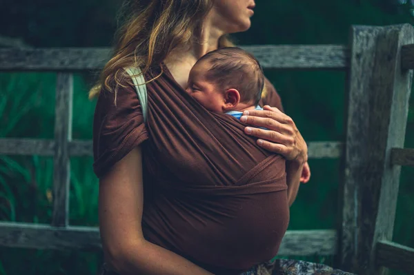 Uma Jovem Mãe Com Seu Bebê Uma Funda Está Descansando — Fotografia de Stock