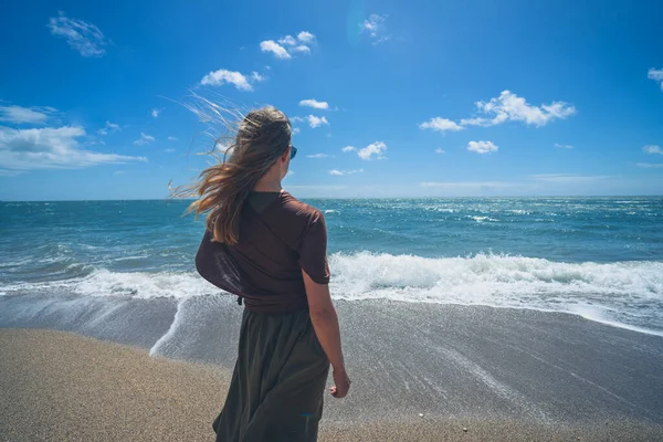 Uma Jovem Está Andando Praia Com Ondas Batendo Dia Ensolarado — Fotografia de Stock