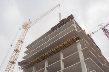 Bir vinç ve gri gökyüzü ile yüksek bir ev bina