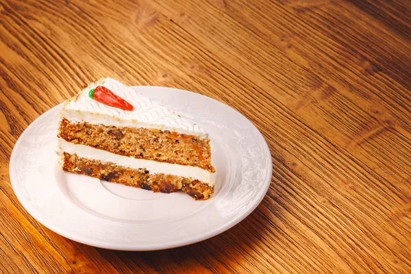 Delicious piece of carrot cake on the wooden table
