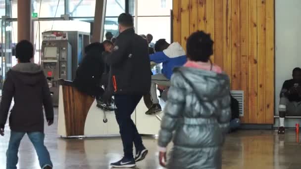 MARSEILLE, FRANCE - 10. november 2018 - To menn lader mobiltelefonen med treningssykkelen på togstasjonen i 4k – stockvideo