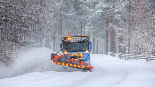 扫雪车清理积雪覆盖的结冰道路 — 图库照片