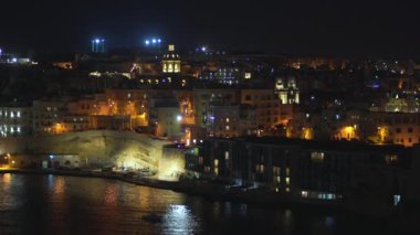 4k şehrin farklı simgeleri ile bir sahil şeridi ve Valletta, Malta şehir panoramik gece görünümü