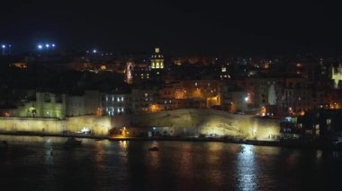 4k şehrin farklı simgeleri ile bir sahil şeridi ve Valletta, Malta şehir panoramik gece görünümü