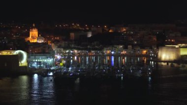 4k şehrin farklı simgeleri ile bir sahil şeridi ve Valletta, Malta şehir panoramik gece görünümü