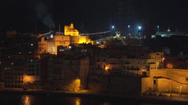 4k şehrin farklı simgeleri ile bir sahil şeridi ve Valletta, Malta şehir panoramik gece görünümü