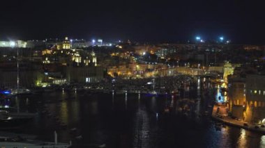 4k şehrin farklı simgeleri ile bir sahil şeridi ve Valletta, Malta şehir panoramik gece görünümü