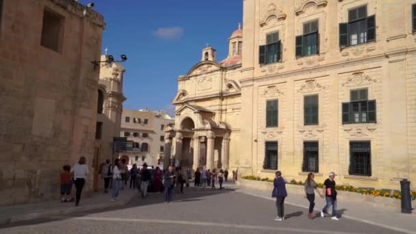 Valletta, malta - 12. November 2018 - aussenansicht der auberge de castille am platz von castille mit menschen, die in 4k vorbeigehen — Stockvideo