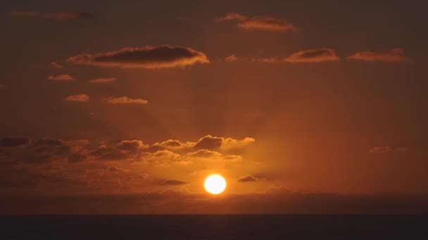Воздушный вид заката неба в море с солнцем спускающимся по горизонту линии с драматическими облаками в 4k — стоковое видео