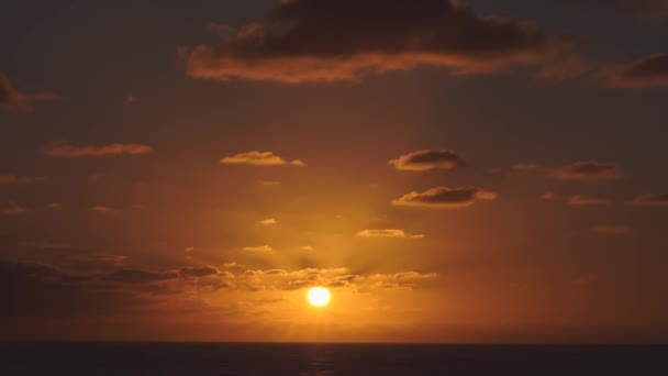 Flygvy över en solnedgång himmel i havet med solen går ner horisonten linje med dramatiska moln i 4k — Stockvideo