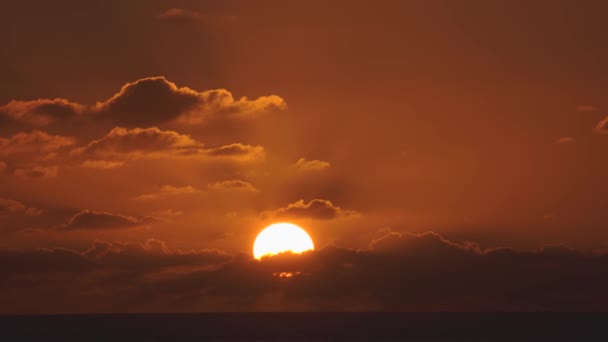 Vista aérea de un cielo al atardecer en el mar con el sol bajando por la línea del horizonte con nubes dramáticas en 4k — Vídeo de stock