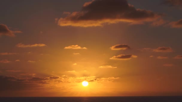 Vista aérea de un cielo al atardecer en el mar con el sol bajando por la línea del horizonte con nubes dramáticas en 4k — Vídeo de stock