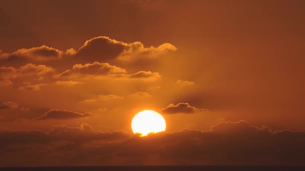 Vista aérea de un cielo al atardecer en el mar con el sol bajando por la línea del horizonte con nubes dramáticas en 4k — Vídeo de stock