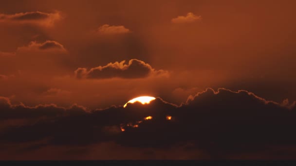 Vista aérea de un cielo al atardecer en el mar con el sol bajando por la línea del horizonte con nubes dramáticas en 4k — Vídeo de stock