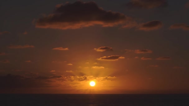 Vista aérea de un cielo al atardecer en el mar con el sol bajando por la línea del horizonte con nubes dramáticas en 4k — Vídeo de stock