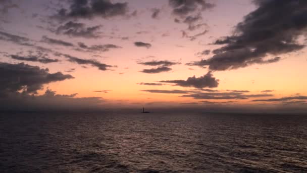 Vista aérea de una puesta de sol cielos crepusculares en el mar con el sol bajando por la línea del horizonte con nubes dramáticas en 4k — Vídeo de stock