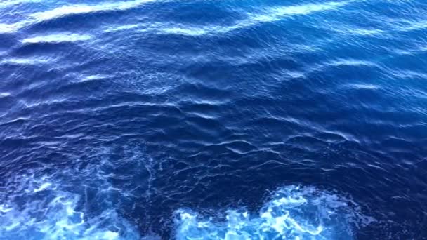 Olas con espuma detrás de un barco en cámara lenta. Patrones de olas en el agua. Vista de la superficie del agua desde el crucero — Vídeos de Stock