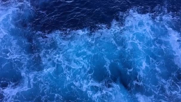 Olas con espuma detrás de un barco en cámara lenta. Patrones de olas en el agua. Vista de la superficie del agua desde el crucero — Vídeos de Stock