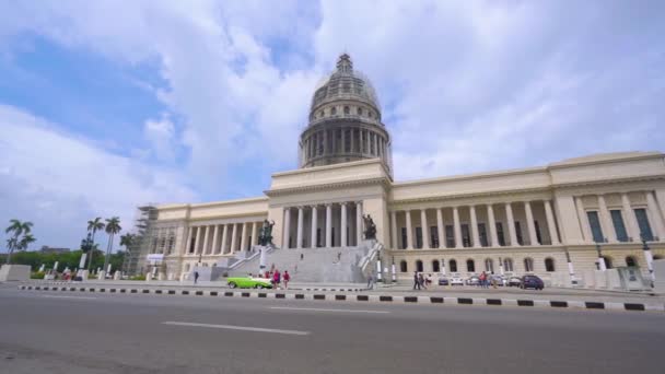 쿠바 아바나 - 2018년 5월 13일 - 엘 카피톨리오 또는 4k 거리에서 빈티지 미국 자동차와 사람들이있는 국립 국회 의사당 건물 — 비디오